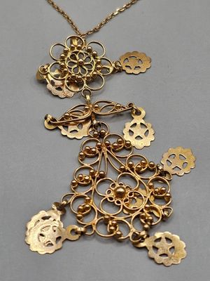un gros plan sur un collier en or orné de plusieurs breloques