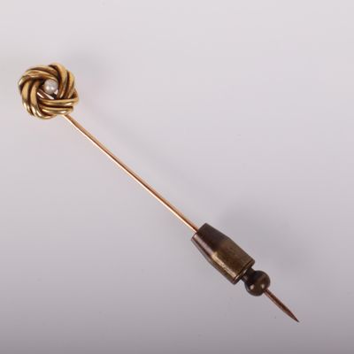 un gros plan d'une broche en or ornée d'un nœud