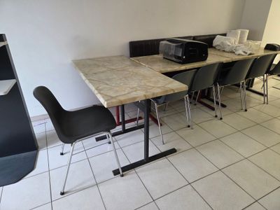 une table sur laquelle se trouvent des chaises et une imprimante, dans une pièce