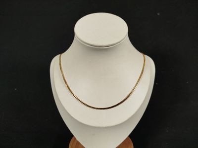 un gros plan d'un collier porté par un mannequin sur fond noir