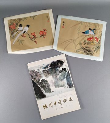 trois peintures chinoises représentant des oiseaux et des fleurs, posées sur une table