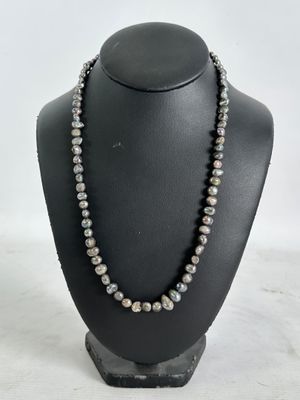 a black and white pearl necklace on a black mannequin