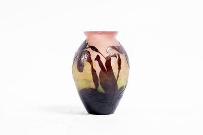 un petit vase orné d'une peinture, posé sur une surface blanche