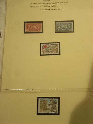 un homme debout devant un mur orné de timbres