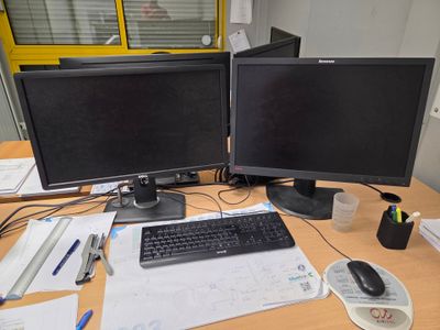 deux écrans d'ordinateur posés sur un bureau, à côté d'un clavier et d'une souris