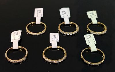 several gold rings with diamonds are on display in a store