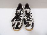 the black and white cow print sneakers are on a white surface