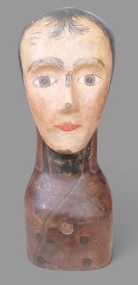 une image représentant un vase en forme de tête en bois sur lequel est peint le visage d'une femme