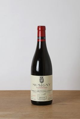 a bottle of red wine sitting on top of a wooden table