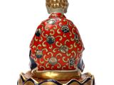 oriental figurine of a buddha sitting on a lotus flower base