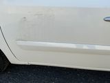 une voiture blanche dont la poignée de porte latérale est sale