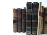 many old books lined up on a shelf together