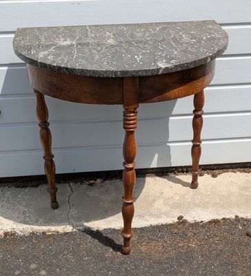 une petite table avec un plateau en marbre