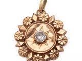 un gros plan d'un pendentif en or orné d'un diamant au centre