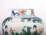 a vase with a painting on it sitting on a table