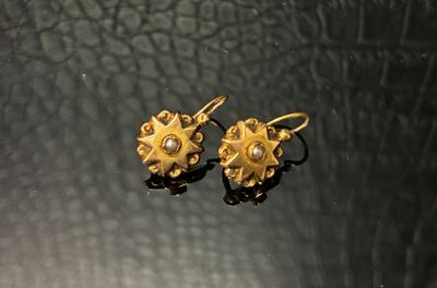 paire de boucles d'oreilles en or et diamants sur fond noir