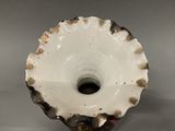an image of a white and black vase with a hole in the middle