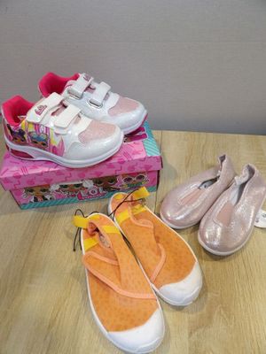 three pairs of shoes sitting on a table next to a box