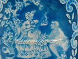 a blue and white plate with a picture of a woman on it