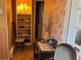 a room with a chair, table, and a book case