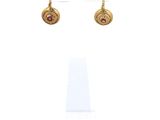 gros plan d'une paire de boucles d'oreilles sur une surface blanche