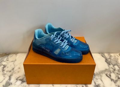 a pair of blue sneakers sitting on top of a box