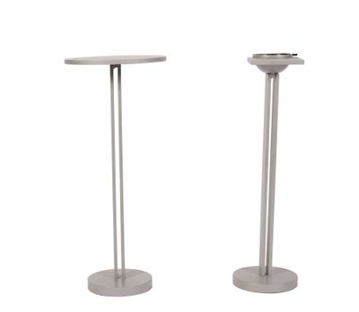pair of metal pedestals with a round table top and a round base