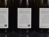 three bottles of wine are lined up on a table