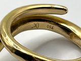 a gold ring with a diamond in it on a white surface