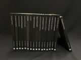 six livres alignés sur une surface noire avec un fond noir