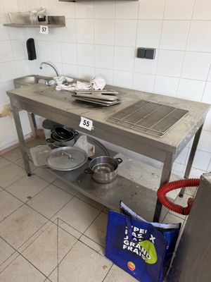 une cuisine avec une table en métal sur laquelle sont posés des casseroles et des poêles