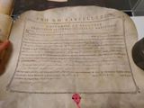 a person holding an old paper with writing on it