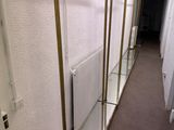 trois étagères en verre fixées au mur à côté d'un radiateur