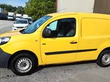 the yellow van is parked in the parking lot next to the building