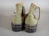 pair of green canvas shoes with black soles on a white surface