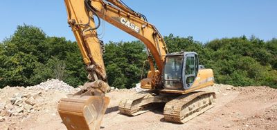 a yellow excavator that is sitting on a pile of dirt