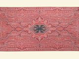 an old red rug with a floral design and fringes on it