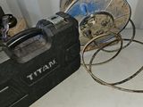 une mallette à outils noire posée par terre à côté de quelques tuyaux
