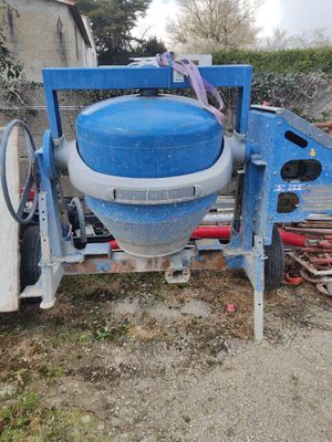 une bétonnière bleue posée dans la terre