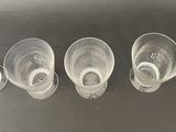 five empty cups sitting on a table next to each other