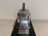 a small metal object that is on a wooden table