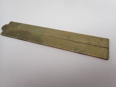 un gros plan d'une plaque en laiton posée sur une surface blanche