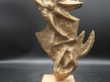 sculpture en bronze représentant une femme tenant un oiseau, posée sur un socle en marbre
