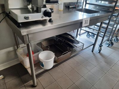 a large stainless steel work table with a cup on it