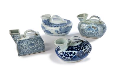 quatre objets en porcelaine bleue et blanche sont disposés sur une surface blanche