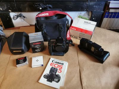 un appareil photo Canon EOS, une batterie Canon, un sac Canon, un appareil photo Canon, une batterie Canon et un appareil photo Canon EOS