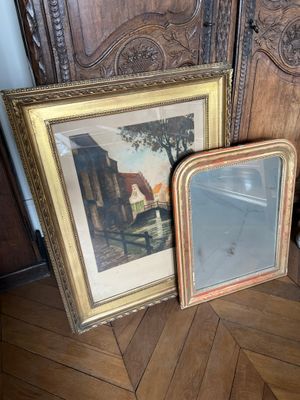 deux photos encadrées posées par terre l'une à côté de l'autre