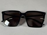 un gros plan sur une paire de lunettes de soleil noires posées sur une surface blanche