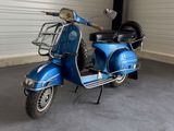 a blue scooter parked in a garage next to a wall