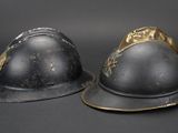 pair of antique fire helmets on a black background